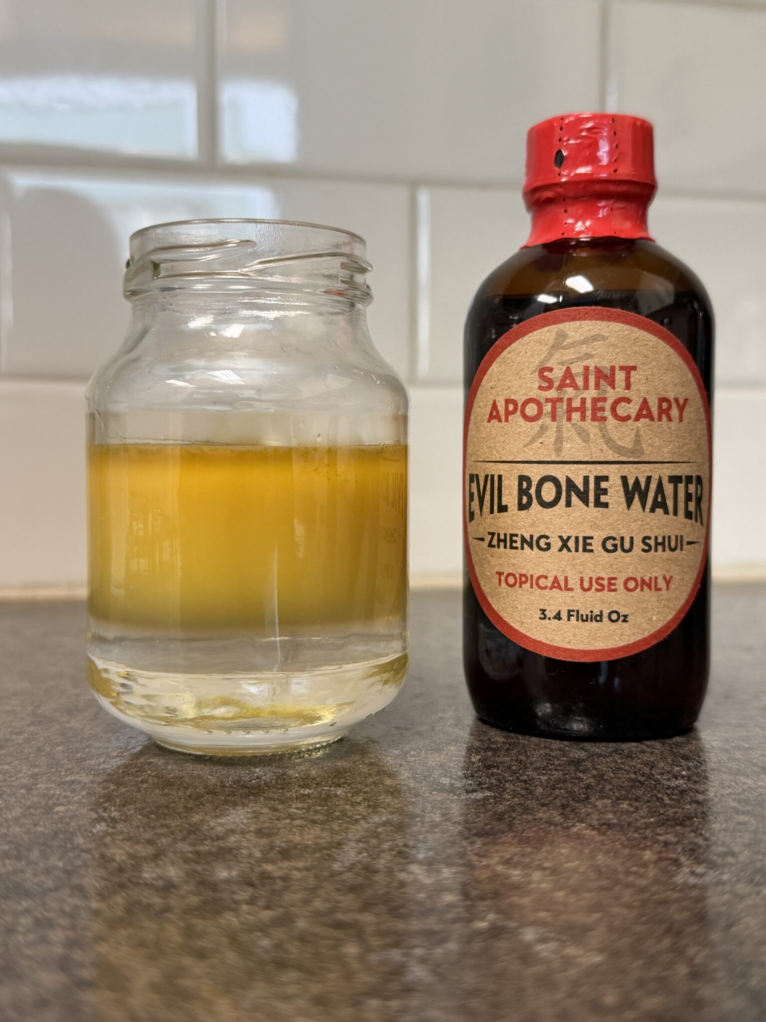 A Cup with Evil Bone Water Mixed with Water Next to a bottle of Evil Bone Water